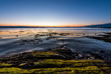 Twilight, dusk in Rimouski, Quebec, Saint Lawrence river, Gaspesie, Canada with rocks, boulders,...