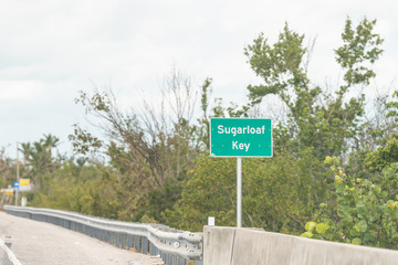 Sugarloaf key island green road, traffic, information sign by ocean, sea in Florida keys, along overseas highway, US1, barrier