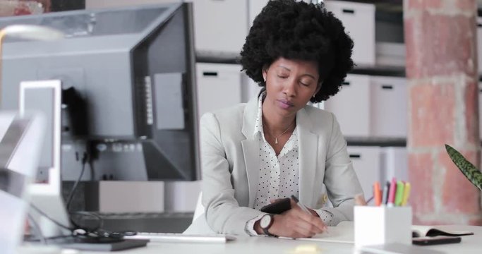 African American businesswoman using smartphone in an office
