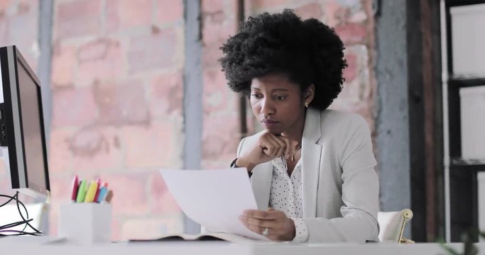 Female african american business executive working in an office looking at paperwork