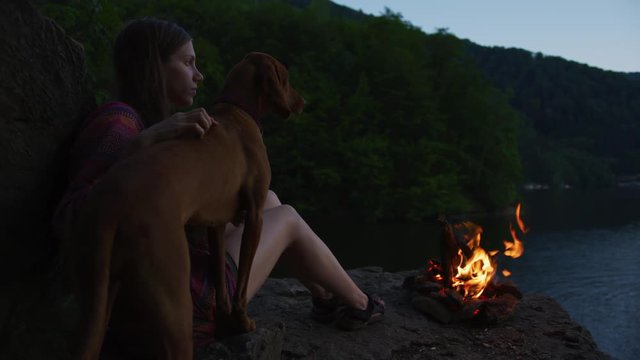 Girl And Dog Standing By A Lake