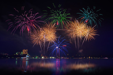 Fototapeta premium Colorful fireworks celebration and the city night light with twilight sky background.