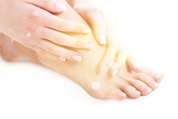 Perfect hands on female feet isolated on white background