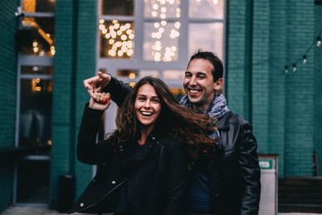  beautiful couple in love walks and dances in the Christmas evening city. Date in the cold.