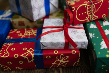 background. Gifts in festive color packaging, lie on a wooden floor. New Year, Christmas, Saint Nicholas, Santa.