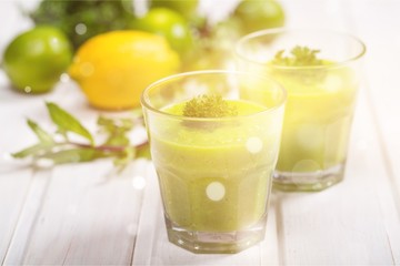 Green vegetable smoothies in glasses on wooden table