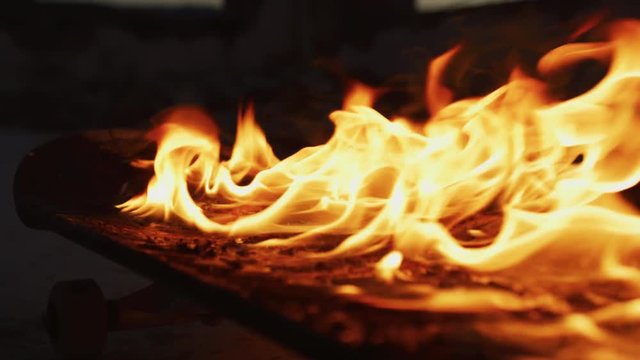 Skateboard on fire, at night