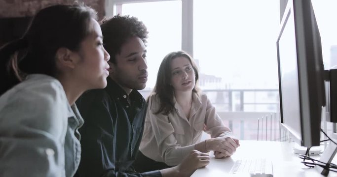 Coworkers looking at a desktop computer together