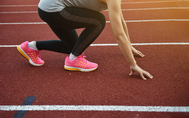 Female athletes  doing start runing in track  sport stadium , the evening sunset , with copy space