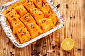 Baked pumpkin with garlic, rosemary and spices on a plate on the table. Appetizer. Garnish. Vegetarian food