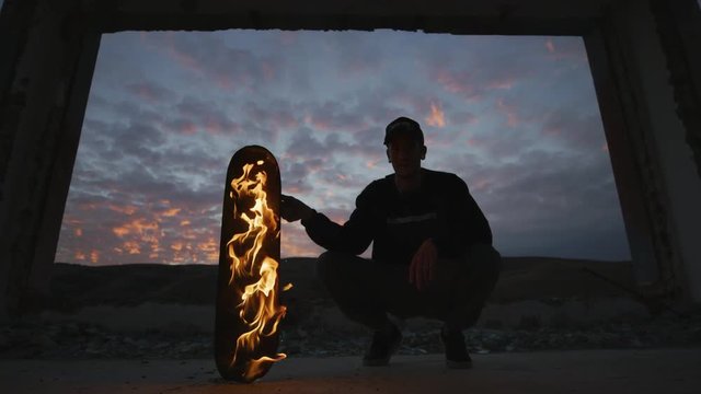 Skateboarder with a burning skateboard