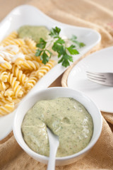 Pasta in white plate, parsley, bowl with mayonnaise sauce