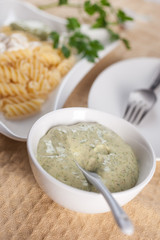 Pasta in white plate, parsley, bowl with mayonnaise sauce