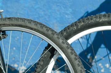 Bicycle wheel close up on a blue wall background.