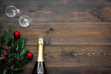 New Year celebration with spruce branch, champagne and glasses wooden table background top view mock up
