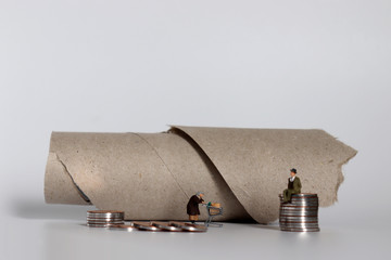 The concept of the gap between rich and poor. A pile of miniature people and coins.