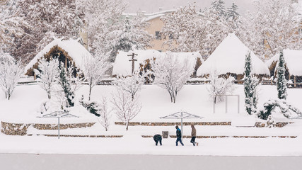 people running in snow - winter landscape with old houses