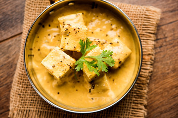 Malai or achari Paneer in a gravy made using Whipping Cream. served on a serving pan. selective focus