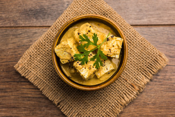 Malai or achari Paneer in a gravy made using Whipping Cream. served on a serving pan. selective focus