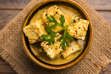 Malai or achari Paneer in a gravy made using Whipping Cream. served on a serving pan. selective focus