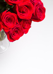 Bouquet of beautiful red roses on white isolated background in glass vase for Valentines day 14 February or International women day 8 March, love romance wedding anniversary celebration, copy space 