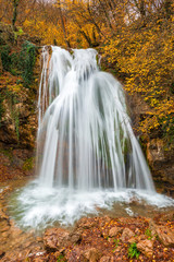 Fototapeta na wymiar Vertical photo of the beautiful waterfall Jur-Jur in the Crimea, autumn landscape