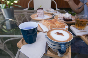 Close up a vintage cup of hot latte coffee on glass desk, coffee with milk