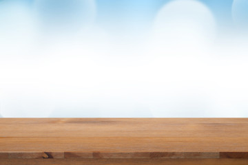 Empty of top wooden desk with blurred light blue gradient bokeh abstract background