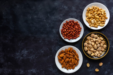 Border with bowls of assorted fresh nuts
