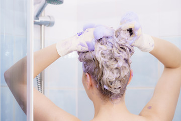 Woman applying toner shampoo on her hair