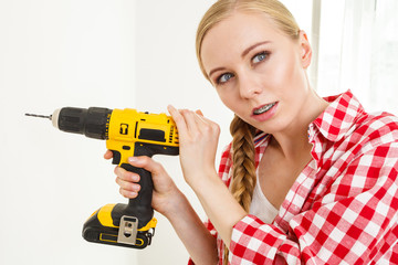 Woman having troubles using drill