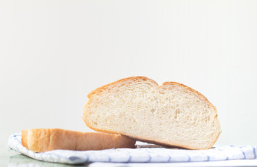 Fresh home made bread on white table background with napkin