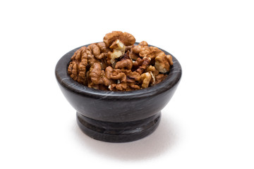 Walnuts in stone bowl on a white isolated background.