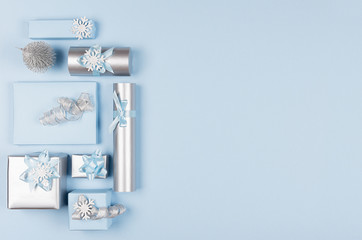 Ideas for design christmas decorations - soft light pastel blue and silver metallic wrapping for gifts and glitter christmas tree with copy space, top view.