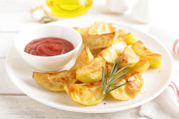 Potato baked and tomato ketchup on white plate, wooden background