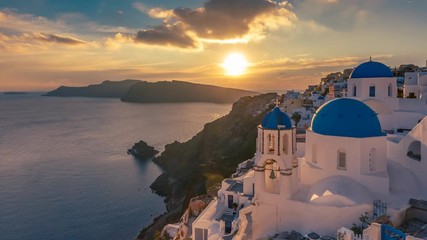 Beautiful view of Churches in Oia village, Santorini island in Greece at sunset, with dramatic sky. 4K day to night transition timelapse. - Powered by Adobe