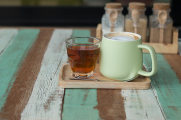 Close up a vintage cup of hot latte coffee on wooden vintage desk, coffee with milk