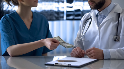 Fototapeta premium Doctor accepting bribe from pharmaceutics company worker, corruption in medicine