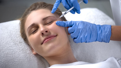 Woman struggling with aging, injections of beauty smoothing wrinkles around eyes