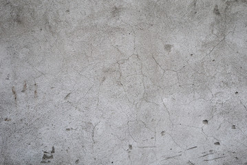 Fragment of an old gray concrete wall with cracks and broken pieces closeup. Background image. You can apply graffiti or your text