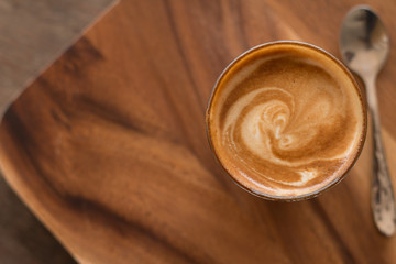 Piccolo Latte art in small glass on wooden desk