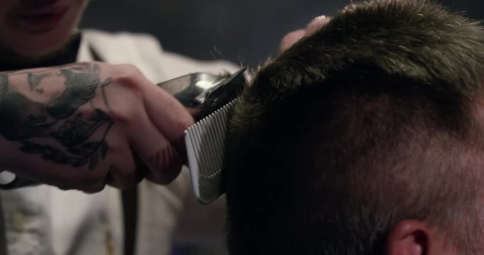 Barber trimming older male client hair in Barbershop slow motion