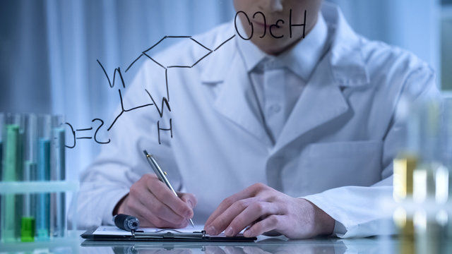 Chemist writing formula on glass and cardboard folder, research in cosmetology