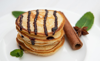 Pancakes with chocolate sauce decorated with fresh mint