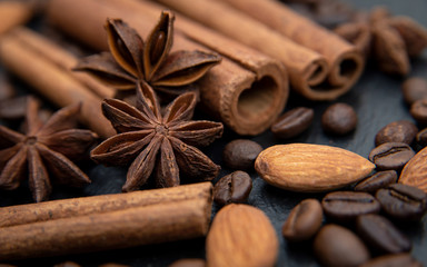 Obraz na płótnie Canvas Spicy background. Cinnamon, almonds, coffee beans and star anise