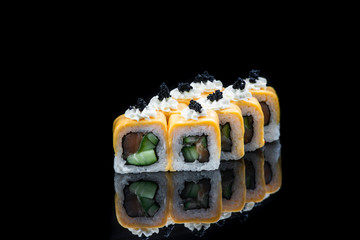 Sushi rolls with salmon, tuna, cucumber and green onions on black background