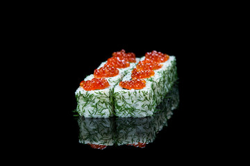 Sushi rolls with salmon, tuna, cucumber and green onions on black background