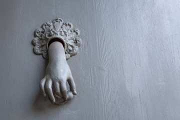 Doorknob in the shape of a woman's hand. Monument, sculpture empty place.
