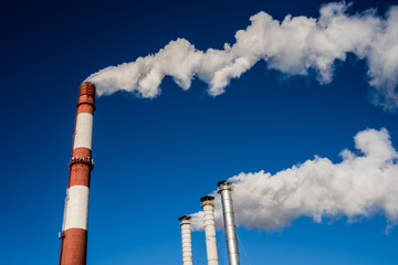 Smoking pipes of thermal power plant against blue sky