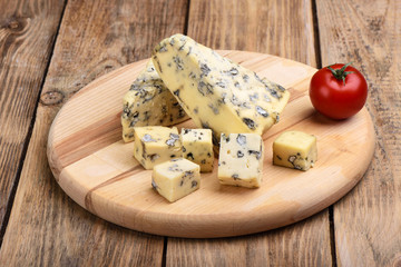Blue mold cheese and fresh tomato on a wooden rustic table